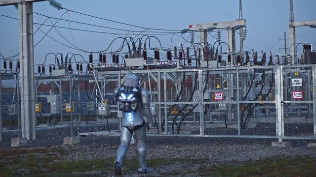 Space man. Evening view at the astronaut walking on between photovoltaic power units while examining ecological technologies. Man working at the sun energy farm. Renewable energy. Sustainable