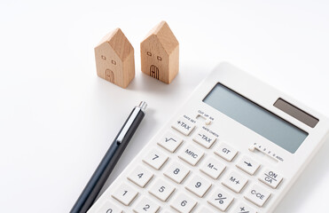 A model of a house, a calculator and a pen on a white background - obrazy, fototapety, plakaty