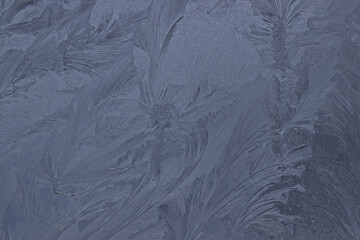 Frosty beautiful pattern on winter glass, natural texture. Blue frosty glass ice background. Winter Christmas, abstract background, frost texture, background, copy space. Small focus
