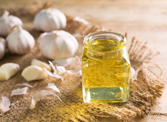Garlic oil on hemp sack with wood background. benefit Prevent coronary artery disease. reduce high...