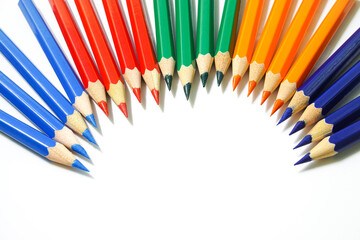 Colored pencils that are separated into multiple colored groups on a white background