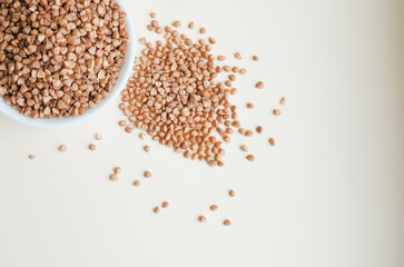 raw buckwheat in a cup on a light background