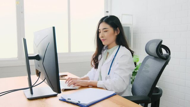 asian woman doctor wear protection face mask work with computer laptop showing a patient  information on digital tablet clip board, patient listen to specialist  in clinic office, medical protect 