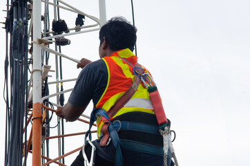Engineer or Technician wear safety equipment climb high telecom tower for maintenance work,working high risk, Installation and Preventive maintenance on telecommunication network 