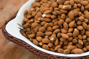 
almonds, in a basket, on a wooden table. 