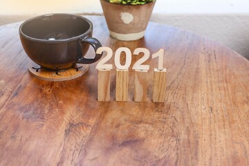 Number 2021 on the wooden sticks with an empty cup on the wooden table 