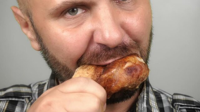 close-up, a man eating a fried chicken leg. Unhealthy food. Home delivery. slow motion FullHD footage