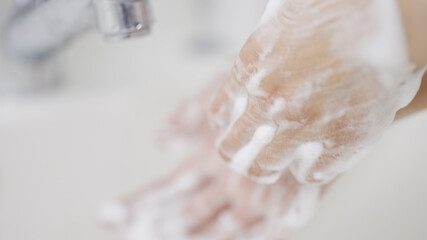 石鹸で手を洗う女性