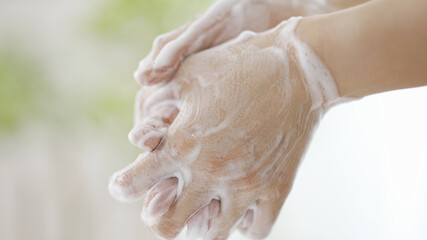 石鹸で手を洗う女性