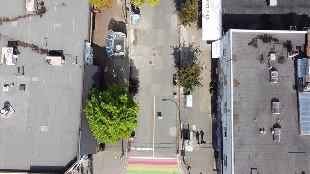 aerial birds eye view fly over downtown Vancouver Gay Pride Village the West End where iconic LGBTQ flag paved on intersection of Davie and Bute on a sunny afternoon with modern portable bathroom 2-4