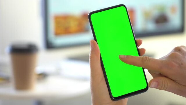 Handheld Camera: Back View of Brunette Man Holding Chroma Key Green Screen Smartphone Watching Content Without Touching or Swiping.