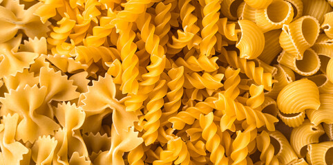 Grocery background of various types of pasta. Top view, panorama. The concept of food.