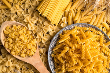 The table is covered with pasta of different varieties. The view from the top. Culinary background....