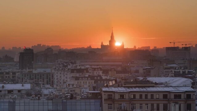beautiful winter sunset in Moscow, the disk of the sun passes through the spire of the main building of the Moscow state University