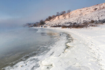 The frozen river is covered with ice. Sea shore in winter. Noise effect.