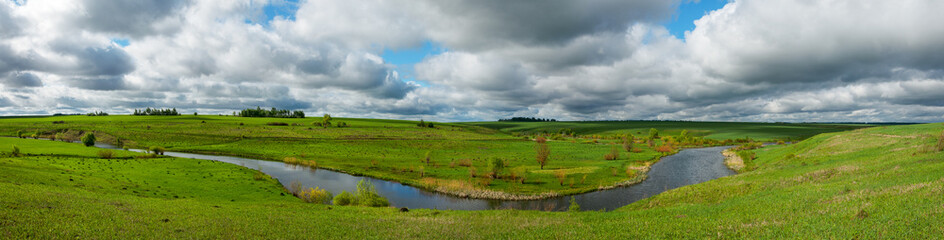 Fototapeta na wymiar Spring panoramic rural landscape with river and green fields