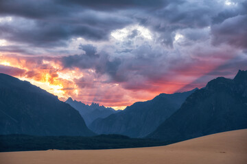 The sky is lit by a pink sunset against the backdrop of the northern desert and mountains
