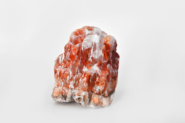 An image of a large red calcite crystal on a white background. 