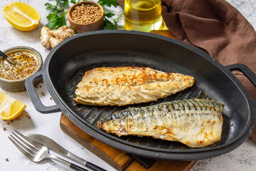 Grilled baked mackerel with ginger mustard honey sauce on a marble table top.