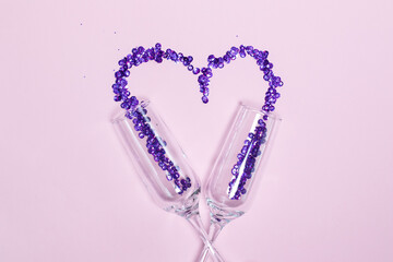 Champagne glass with Very Peri sequins scattered in the form of heart. Valentine's Day decor