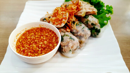 Close up Vietnamese steamed rice-skin dumplings and fried onion on top with sweet peanut bean sauce on white dish or plate. Asian food and Famous meal in Vietnam.