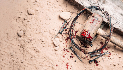 Old wooden cross, hammer, bloody nails and crown of thorns on ground. Banner. Copy space. Good...