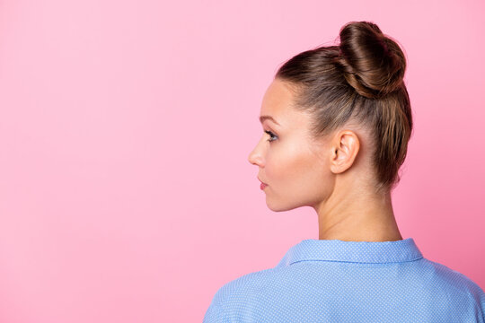 Rare view photo portrait of girl bun hairstyle looking at blank space serious confident isolated on pastel pink color background