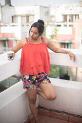 Lifestyle portrait of an Indian Bengali young girl in red casual wear inside Indian household. Indian lifestyle and fashion