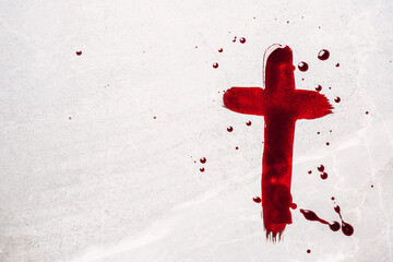 Christian cross painted with red blood on stone background. Copy space. Good friday. Passion,...