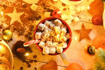sweet food top view background for merry christmas or new year holiday decoration with night illumination - chocolate candies, tangerines, cookies, marshmallow and cocoa latte on white wood