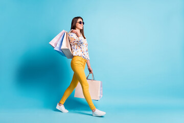 Profile photo of cute lady go carry mall packets wear sunglass geometry print shirt yellow pants...