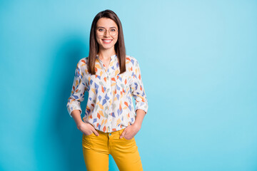 Photo of lovely young girl hands pockets beaming smiling wear eyewear geometry print shirt yellow pants isolated blue color background
