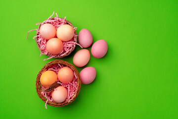 Fototapeta na wymiar Easter eggs in a nest on green background