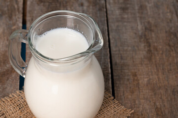 Glass jar of milk on old wooden table