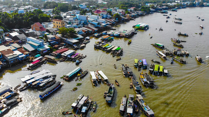 Obraz premium Aerial view of Cai Rang floating market, Can Tho, Vietnam. Cai Rang is famous market in mekong delta, Vietnam. Tourists, people buy and sell food, vegetable, fruits on boat, ship