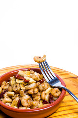 Prawns with garlic and cayenne in a ceramic bowl on a wooden tray