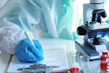 Close up of doctor's hands making notes on table
