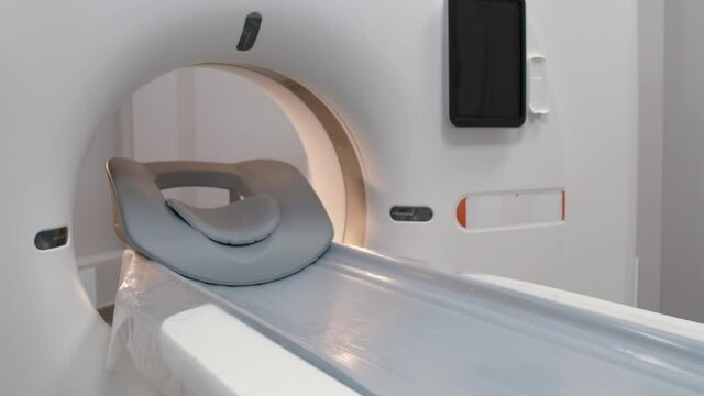 PAN slowmo of empty treatment couch moving into CT scan machine