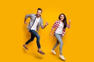 Fototapeta na wymiar Photo portrait full body view of crazy couple jumping up running isolated on vivid yellow colored background