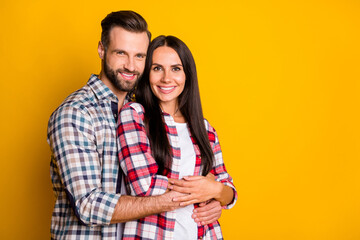 Photo portrait of man hugging woman from behind isolated on vivid yellow colored background with blank space