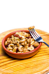 Prawns with garlic and cayenne in a ceramic bowl on a wooden tray
