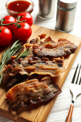 Concept of tasty snack with fried bacon on wooden background