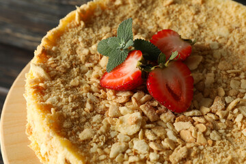 Stand with Napoleon cake with strawberry on wooden background