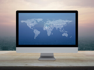 Start up business icon with global words world map on desktop modern computer monitor screen on wooden table over city tower and skyscraper at sunset sky, vintage style, Happy new year 2021 start up o
