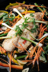 chinese style steamed fish fillet with vegetables on hot plate
