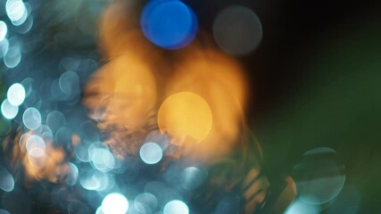 Festive background. Colored spots and lanterns from Christmas toys and tinsel on the Christmas tree against the background of the fireplace flame. Out of focus.