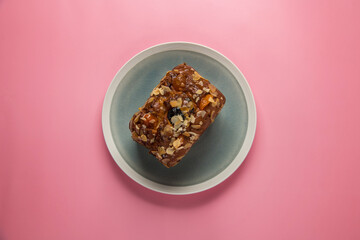 Christmas composition. Delicious honey muffin with a nut on a bright pink background.