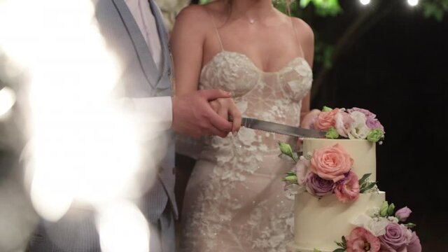 Bride and groom cut a beautiful wedding cake. High quality FullHD footage