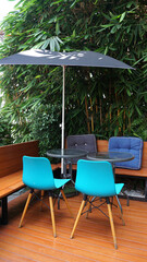 Outdoor furniture set with Blue plastic chair and wooden legs on timber deck