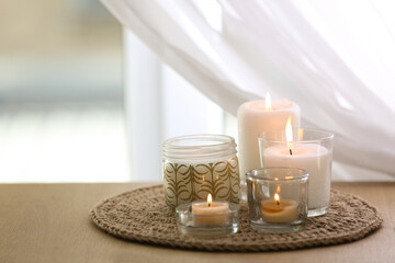 Beautiful burning candles on table at home